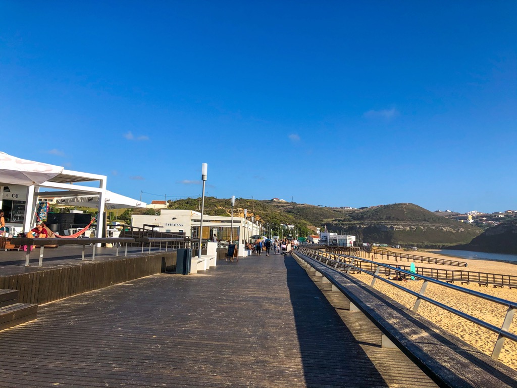 A beach boardwalk lined with restaurants at Foz do Lizandro